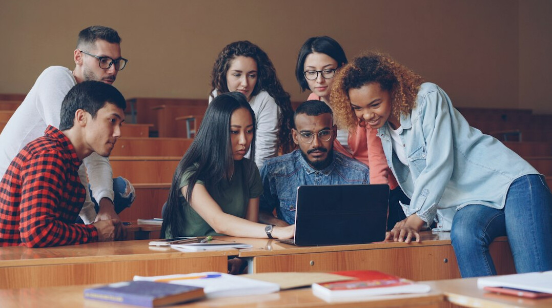 group of students in classroom discussing code