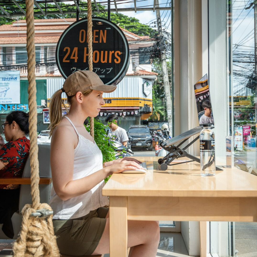 person coding successfully on laptop at cafe