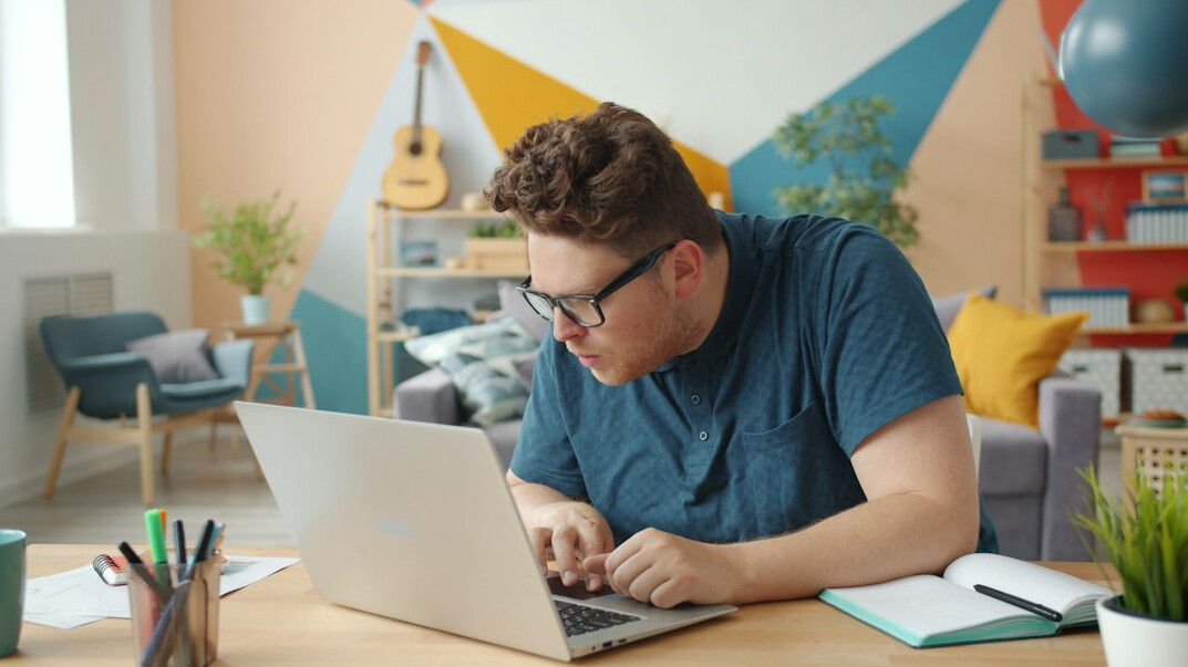 student studying coding at home desk