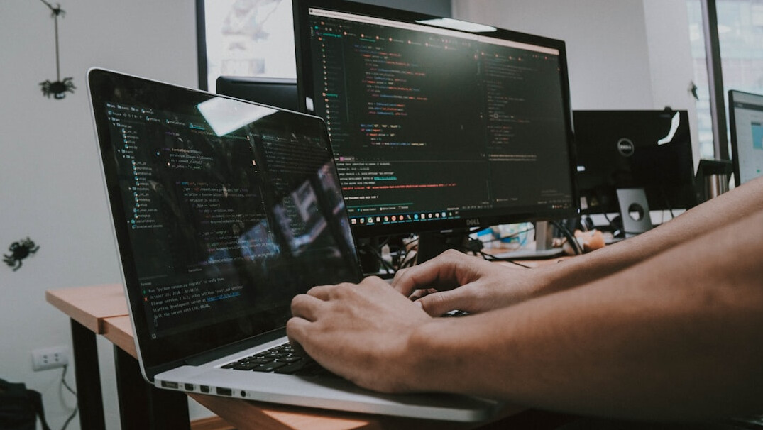 person debugging code on laptop